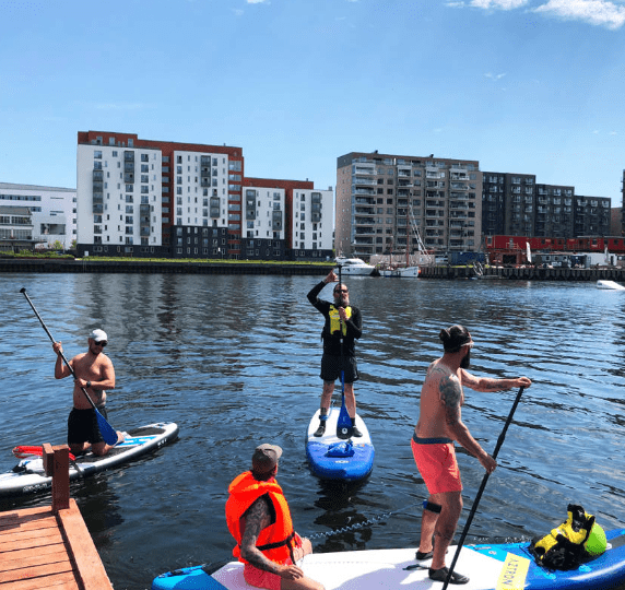 4 personer oever paa Stand up paddle board