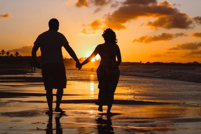 Et par der loeber paa stranden og holder i hånden