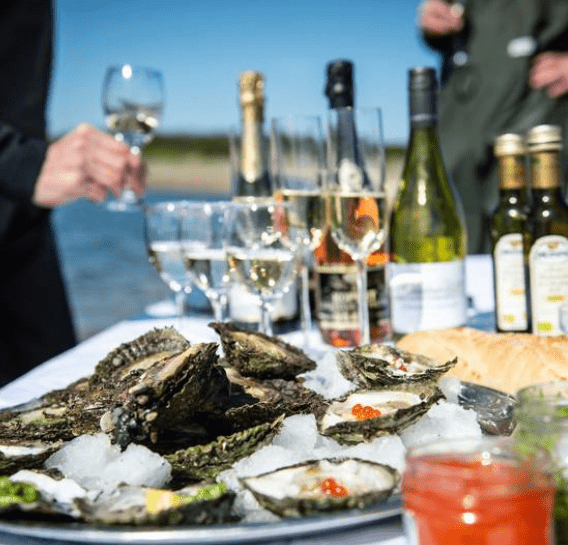 et bord udendoers med oesters og champagne som oplevelsesgave